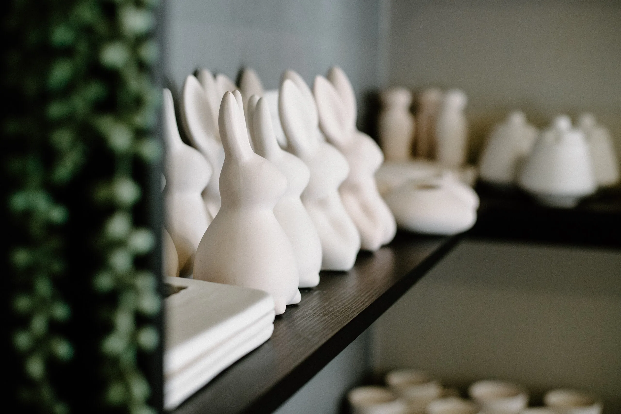 Unpainted ceramic pieces lined up on a shelf